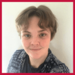 A person with short, light brown hair smiles at the camera. They wear a patterned shirt over a dark top and stand in front of a plain white wall, with a red border framing the image.