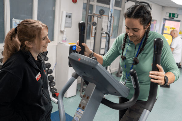 exercise therapist chatting to service user in gym